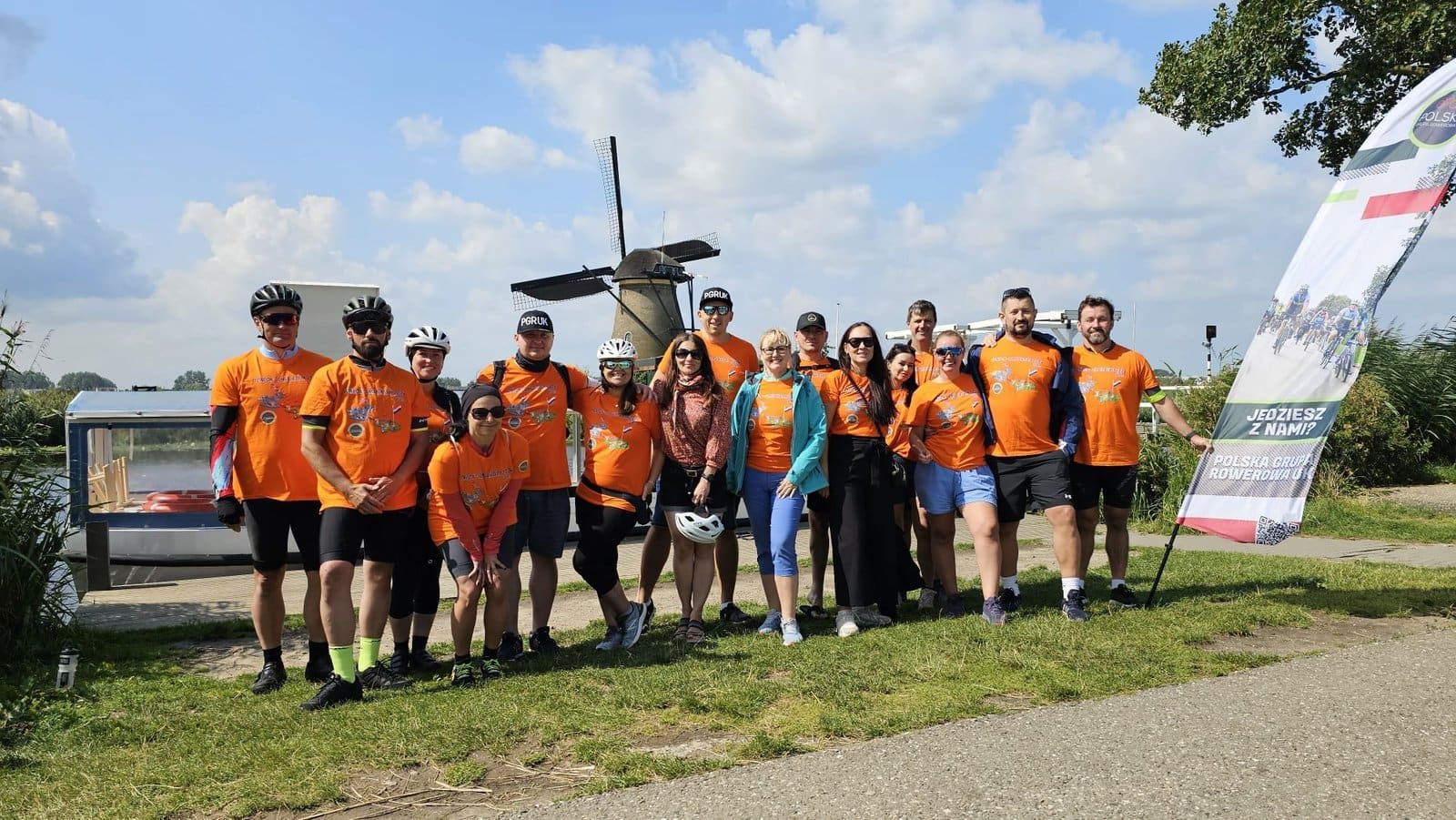 A group in orange jerseys by a windmill, Harwich